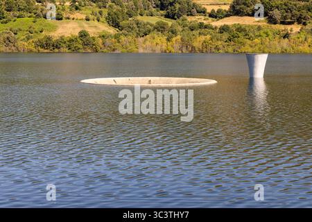 Ein großer Wasserkörper mit einem kleinen Loch in der Mitte. Das Wasser ist ruhig und ruhig Stockfoto
