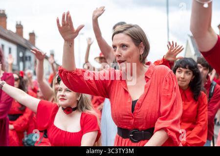Birmingham, Großbritannien. Juli 2025. 300 Menschen treffen sich zusammen, um eine Tanzroutine namens Most Wuthering Heights Ever in Kings Heath, Birmingham, Großbritannien, aufzuführen. Die Teilnehmer, alle in rot gekleidet, wurden von Jess Phillips, Labour-Abgeordneter für Yardley, Birmingham, angesprochen, bevor sie das Musikvideo für Kate Bushs ikonisches Lied „Wuthering Heights“ reproduzierten. Frau Phillips schließt sich dem expressiven Tanz an. Die Veranstaltung sammelt Gelder für Women's Empowerment and Recovery Educators und ANAWIM Charitations. Quelle: Peter Lopeman/Alamy Live News Stockfoto