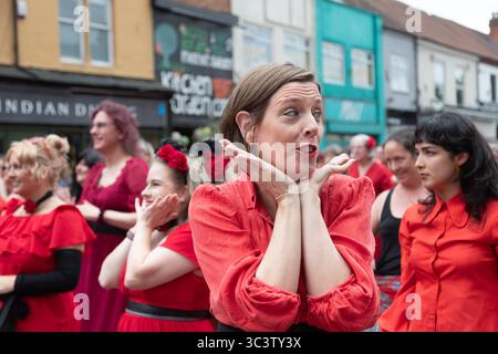 Birmingham, Großbritannien. Juli 2025. 300 Menschen treffen sich zusammen, um eine Tanzroutine namens Most Wuthering Heights Ever in Kings Heath, Birmingham, Großbritannien, aufzuführen. Die Teilnehmer, alle in rot gekleidet, wurden von Jess Phillips, Labour-Abgeordneter für Yardley, Birmingham, angesprochen, bevor sie das Musikvideo für Kate Bushs ikonisches Lied „Wuthering Heights“ reproduzierten. Frau Phillips schließt sich dem expressiven Tanz an. Die Veranstaltung sammelt Gelder für Women's Empowerment and Recovery Educators und ANAWIM Charitations. Quelle: Peter Lopeman/Alamy Live News Stockfoto