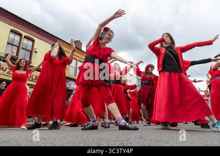 Birmingham, Großbritannien. Juli 2025. 300 Menschen treffen sich zusammen, um eine Tanzroutine namens Most Wuthering Heights Ever in Kings Heath, Birmingham, Großbritannien, aufzuführen. Die Teilnehmer, alle in rot gekleidet, wurden von Jess Phillips, Labour-Abgeordneter für Yardley, Birmingham, angesprochen, bevor sie das Musikvideo für Kate Bushs ikonisches Lied „Wuthering Heights“ reproduzierten. Die Veranstaltung sammelt Gelder für Women's Empowerment and Recovery Educators und ANAWIM Charitations. Quelle: Peter Lopeman/Alamy Live News Stockfoto