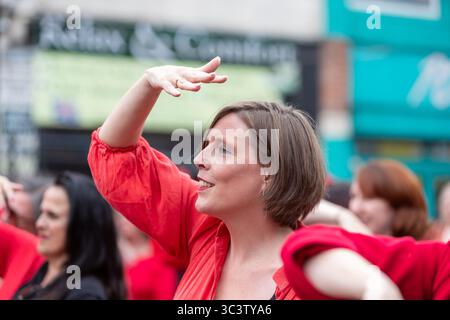 Birmingham, Großbritannien. Juli 2025. 300 Menschen treffen sich zusammen, um eine Tanzroutine namens Most Wuthering Heights Ever in Kings Heath, Birmingham, Großbritannien, aufzuführen. Die Teilnehmer, alle in rot gekleidet, wurden von Jess Phillips, Labour-Abgeordneter für Yardley, Birmingham, angesprochen, bevor sie das Musikvideo für Kate Bushs ikonisches Lied „Wuthering Heights“ reproduzierten. Frau Phillips schließt sich dem expressiven Tanz an. Die Veranstaltung sammelt Gelder für Women's Empowerment and Recovery Educators und ANAWIM Charitations. Quelle: Peter Lopeman/Alamy Live News Stockfoto
