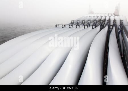 Transport von Rotorblättern für Windturbinen auf einem Frachtschiff im Nebel über den Ozean. Stockfoto