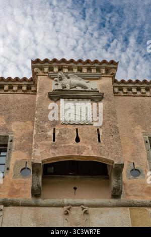Detail des historischen Torturms in Motovun, Kroatien, mit geschnitztem venezianischem Löwenrelief und Wappen auf verwitterter Steinfassade mit Crene Stockfoto