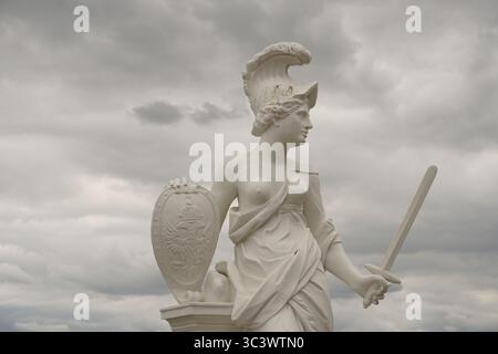 Seitenprofil Porträt einer weißen Marmorstatue der antiken griechischen Göttin Europa (Europa) mit Helm, Schwert, Schild vor einem stürmischen und bewölkten Himmel Stockfoto