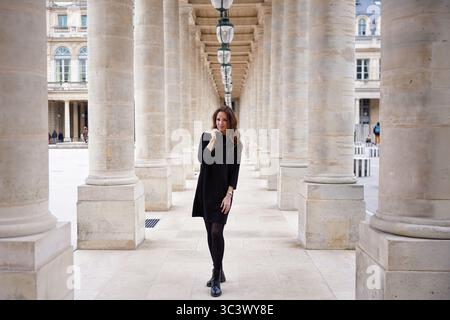Modische Frau, die im Palais Royal Colonnade Paris spaziert Stockfoto