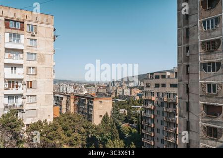 Fotos von alten Wohngebäuden aus Betonplatten aus den 1970er Jahren in Tiflis, Georgien. Diese ikonischen Beispiele brutalistischer Architektur aus der Sowjetzeit spiegeln den krassen, utilitaristischen Stil jener Zeit wider. Rohtexturen, sich wiederholende Geometrien und verwitterte Fassaden sprechen vom historischen und sozialen Kontext der Stadtentwicklung während der Sowjetzeit. Stockfoto
