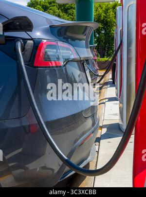 Elektroautos laden auf einem Parkplatz mit einer Elektroauto-Ladestation in Nebraska Stockfoto