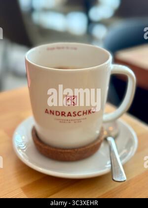 Nahaufnahme einer weißen Kaffeetasse mit der Aufschrift „Andraschko“ auf einer Untertasse mit Löffel in einem Café in Lübeck. Stockfoto