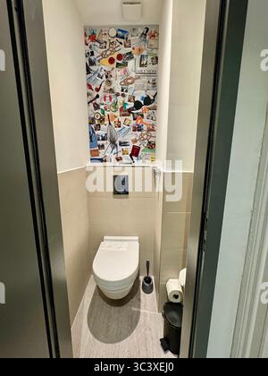 Moderne Hoteltoilette mit kreativer Collage-Wandkunst im NIU Hotel in Deutschland mit minimalistischem und stilvollem Innendesign. Stockfoto