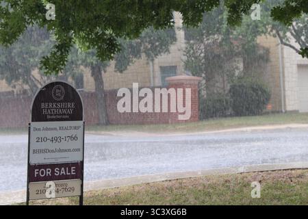 San Antonio, USA. Juli 2025. Ein Berkshire Hathaway Home Services Immobilienschild steht während es am 27. Juli 2025 in der Joint Base San Antonio (JBSA) Lackland Area in San Antonio, Texas, USA, regnet. Berkshire Hathaway Home Services ist ein Immobiliennetzwerk, das sich über vier Kontinente erstreckt und über 50.000 Immobilienfachleute umfasst. (Foto: Carlos Kosienski/SIPA USA) Credit: SIPA USA/Alamy Live News Stockfoto