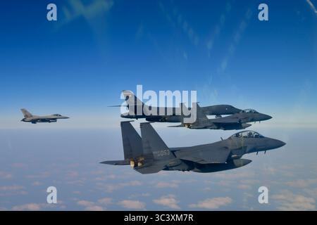 Eine F-16 der US Air Force (links) fliegt in Formation mit einem B-1B Lancer der US Air Force (Mitte) und zwei F-15K Slam Eagles (Dura) der Republik Korea Stockfoto