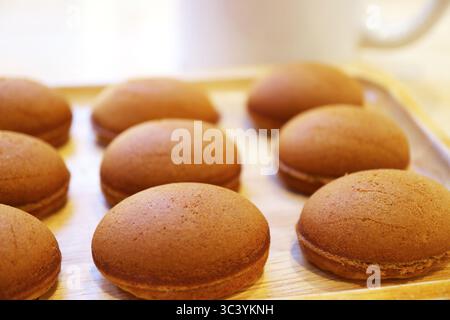 Köstliche hausgemachte Mini-Kaffeekuchen auf einem hölzernen Breadboard Stockfoto