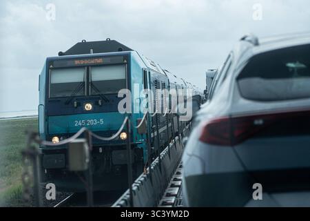 Überfahrt von Niebüll nach Westerland auf Sylt mit dem blauen Autozug der RDC AUTOZUG Sylt GmbH - Begegnung mit RegionalExpress auf dem HindenburgdammBlick auf einen Teilabschnitt der von Hamburg und nach Sylt führenden Marschbahn mit dem Hindenburgdamm in Schleswig-Holstein zwischen den Stationen Niebüll und Westerland auf der Insel Sylt, Berlin Berlin Deutschland ORTSANGABE *** Überquerung von Niebüll nach Westerland auf Sylt mit dem blauen AUTOZUG der RDC AUTOZUG Sylt GmbH Treffen mit RegionalExpress am Hindenburgdamm Ansicht eines Abschnitts der Sumpfbahn von Hamburg nach Sylt Stockfoto