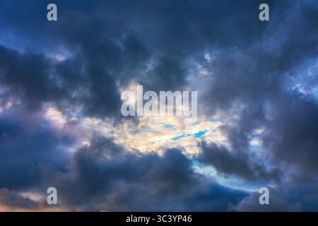 Dramatische Wolkenlandschaften mit dunklen und hellen Wolken. Der Himmel ist mit einer Vielzahl von Wolkenformationen gefüllt, die Regenwetter erzeugen Stockfoto