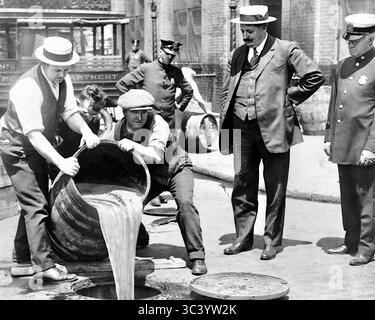 Verbotsentsorgung - New York City Deputy Police Commissioner John A. Leach, rechts, beobachtete Agenten, wie sie Alkohol in die Kanalisation gießen, nach einer Razzia -1921 Stockfoto