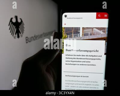 Stuttgart, Deutschland - 06.11.2025: Person, die ein Handy hält, mit Webseite des Bundesverfassungsgerichts (BVerfG) vor dem Logo auf dem Bildschirm. Stockfoto