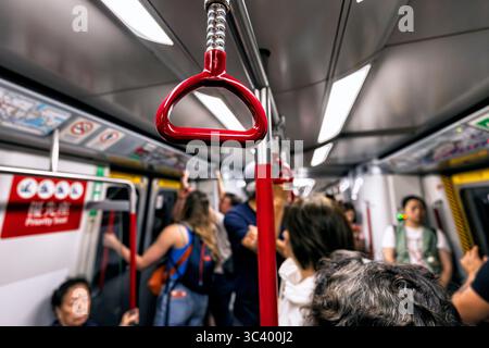 Passagiere und Aufhängeschlaufe in der U-Bahn, Hongkong, SAR, China Stockfoto