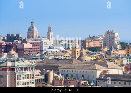 Ein Blick aus der Höhe auf das historische Zentrum von Genua mit Kuppeln, Glockentürmen und farbenfrohen Gebäuden unter einem klaren Sommerhimmel Stockfoto
