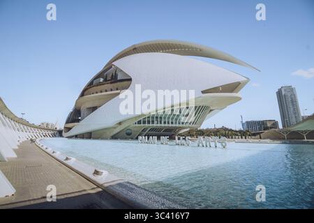 Valencia, Spanien - 16. April 2025: Blick auf den Palau de les Arts Reina Sofia im ruhigen Wasser unter einem weiten, wolkenlosen Himmel, ein modernes architektonisches Wunder. Stockfoto