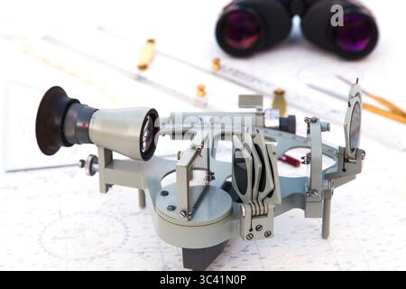 Navigationstools befinden sich auf der Navigationskarte. Sextant, Plotter, Teiler, Lineal und Fernglas. Stockfoto
