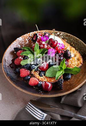 Ein Teller französischer Toast mit frischen Beeren und Schlagsahne, serviert als köstlicher und optisch ansprechender Brunch. Hausgemachte süße Frühstückskappe Stockfoto