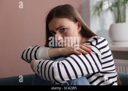 Besorgte Frau, die zu Hause an Paranoia leidet Stockfoto