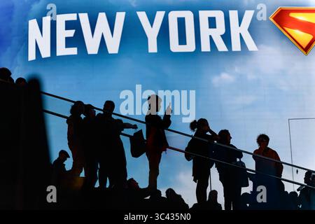 Silhouette Eines Mannes, der Telefonfotos unter Einer Menge auf den TKTS-Stufen vor Einer riesigen digitalen Reklametafel am Times Square, New York, USA macht. Stockfoto