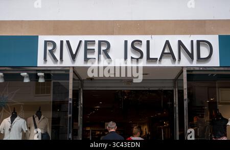 Windsor, Berkshire, Großbritannien. Juli 2025. Dem Vernehmen nach besteht die Gefahr eines Zusammenbruchs der High Street Modekette River Island aufgrund sinkender Verkäufe und schwieriger Handelsbedingungen. „Die Vermieter, die den Rettungsplan von River Island unterstützen, sind auf erhebliche Mietsenkungen ausgerichtet, wobei einige im Rahmen einer Umstrukturierung, die von der Gründerfamilie Lewis geleitet wurde, Kürzungen von bis zu 100 % drohen. Der Plan der umstrittenen Modekette wird 33 Geschäfte schließen und bei 71 anderen Mietsenkungen anstreben, wobei einige Vermieter eine Reduzierung von 25 % oder 40 % erwarten, während einige davon möglicherweise überhaupt keine Miete erhalten. Die Lewis-Familie, durch ihre Investoren Stockfoto
