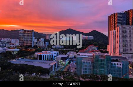 Die atemberaubende Fotografie bei Sonnenuntergang entfaltet sich in den Batu Caves Malaysia, wo der Himmel der goldenen Stunde auf Stadtturmlichter und Straßenbeleuchtung trifft. Von Stockfoto