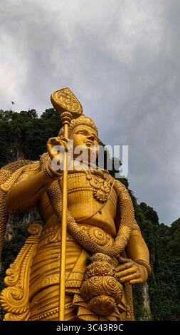 Die atemberaubende Fotografie bei Sonnenuntergang entfaltet sich in den Batu Caves Malaysia, wo der Himmel der goldenen Stunde auf Stadtturmlichter und Straßenbeleuchtung trifft. Von Stockfoto