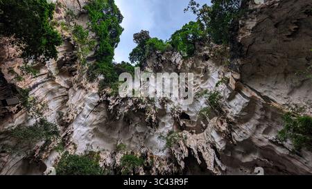 Die atemberaubende Fotografie bei Sonnenuntergang entfaltet sich in den Batu Caves Malaysia, wo der Himmel der goldenen Stunde auf Stadtturmlichter und Straßenbeleuchtung trifft. Von Stockfoto