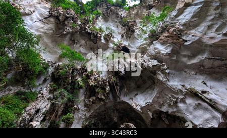 Die atemberaubende Fotografie bei Sonnenuntergang entfaltet sich in den Batu Caves Malaysia, wo der Himmel der goldenen Stunde auf Stadtturmlichter und Straßenbeleuchtung trifft. Von Stockfoto