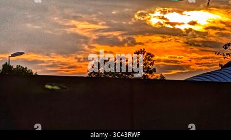 Die atemberaubende Fotografie bei Sonnenuntergang entfaltet sich in den Batu Caves Malaysia, wo der Himmel der goldenen Stunde auf Stadtturmlichter und Straßenbeleuchtung trifft. Von Stockfoto