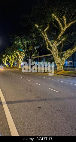 Die atemberaubende Fotografie bei Sonnenuntergang entfaltet sich in den Batu Caves Malaysia, wo der Himmel der goldenen Stunde auf Stadtturmlichter und Straßenbeleuchtung trifft. Von Stockfoto