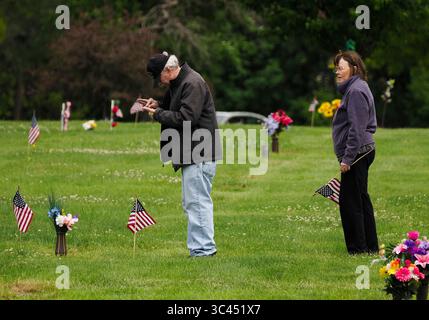 28. Mai 2021, SIOUX CITY, IOWA, USA: CRAIG HANSEN aus Sioux Falls, SD, überprüft den Fokus auf seiner Handykamera, während er Fotos von den Grabmarkierungen seines Vaters und eines Bruders macht, nachdem er und seine Frau Claudia am Samstag, 29. Mai 2021, Blumen und amerikanische Flaggen an Familienmitglieder auf dem Memorial Park Cemetery in Sioux City, Iowa, angebracht haben. Die Hansens wuchsen beide in Sioux City auf. Während der Woche brachten die örtlichen Strafverfolgungsbehörden und Mitglieder der Iowa Air National Guard und der Army National Guard kleine amerikanische Flaggen auf die Gräber von Veteranen. (Bild: © Jerry Mennenga/ZUMA Wire) Stockfoto