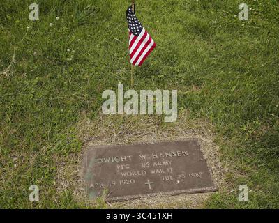 28. Mai 2021, SIOUX CITY, IOWA, USA: CRAIG HANSEN aus Sioux Falls, SD, fotografiert jedes Jahr den Grabmarker seines Vaters, nachdem er und seine Frau Claudia am Samstag, 29. Mai 2021, Blumen an Familienmitglieder auf dem Memorial Park Cemetery in Sioux City, Iowa, ausgestellt haben. Die Hansens wuchsen beide in Sioux City auf. In der vergangenen Woche legten lokale Strafverfolgungsbehörden und Mitglieder der Iowa Air National Guard und der Army National Guard kleine amerikanische Flaggen auf die Gräber von Veteranen. (Bild: © Jerry Mennenga/ZUMA Wire) Stockfoto
