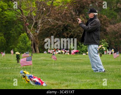28. Mai 2021, SIOUX CITY, IOWA, USA: CRAIG HANSEN aus Sioux Falls, SD, fotografiert die Grabmarkierungen seines Vaters und eines Bruders, nachdem er und seine Frau Claudia am Samstag, 29. Mai 2021, Blumen an Familienmitglieder auf dem Memorial Park Cemetery in Sioux City, Iowa, ausgestellt haben. Die Hansens wuchsen beide in Sioux City auf. In der vergangenen Woche legten lokale Strafverfolgungsbehörden und Mitglieder der Iowa Air National Guard und der Army National Guard kleine amerikanische Flaggen auf die Gräber von Veteranen. (Bild: © Jerry Mennenga/ZUMA Wire) Stockfoto