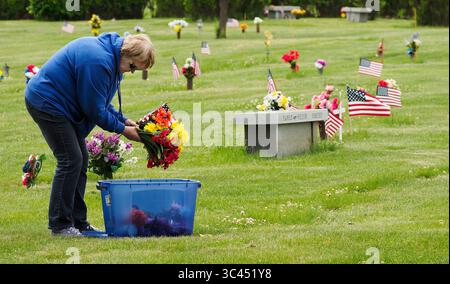 28. Mai 2021, SIOUX CITY, IOWA, USA: CAROL WASHBURN aus des Moines bringt Blumen und eine kleine amerikanische Flagge hervor, während er an Familienmitglieder auf dem Memorial Park Cemetery in Sioux City, Iowa, erinnert. Samstag, 29. Mai 2021. Washburn wuchs in einer kleinen Gemeinde Nebraska auf, direkt gegenüber dem Missouri River von Sioux City. Während der Woche brachten die örtlichen Strafverfolgungsbehörden und Mitglieder der Iowa Air National Guard und der Army National Guard kleine amerikanische Flaggen auf die Gräber von Veteranen. (Bild: © Jerry Mennenga/ZUMA Wire) Stockfoto