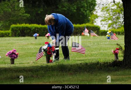 28. Mai 2021, SIOUX CITY, IOWA, USA: CAROL WASHBURN von des Moines platziert ein Kreuz neben einer kleinen amerikanischen Flagge auf dem Grab eines Familienmitglieds auf dem Memorial Park Cemetery in Sioux City, Iowa Samstag, 29. Mai 2021. Washburn wuchs in einer kleinen Gemeinde Nebraska auf, direkt gegenüber dem Missouri River von Sioux City. Während der Woche brachten die örtlichen Strafverfolgungsbehörden und Mitglieder der Iowa Air National Guard und der Army National Guard kleine amerikanische Flaggen auf die Gräber von Veteranen. (Bild: © Jerry Mennenga/ZUMA Wire) Stockfoto