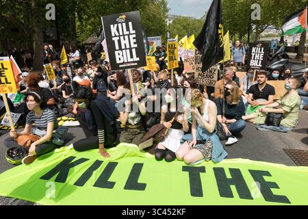 29. Mai 2021, London, Vereinigtes Königreich: Demonstranten, die Plakate halten, sitzen solidarisch gegen die Gesetzesvorlage der Regierung für eine Erhöhung des Polizeibudgets während des Mordes Bill. Im März 2021 schlug die britische Regierung den Police and Crime Bill 2021 vor, der vorgab, die Polizeirechte auszuweiten. Seit seiner Veröffentlichung stieß er auf weitverbreitete Skepsis in der Öffentlichkeit und wurde in der Folge zum Gegenstand von Protesten. Dieser Protest am 29. Mai 2021 wurde von der britischen Niederlassung von Black Lives Matter geführt, die speziell gegen den Einsatz von Polizeigewalt als Mittel zur Schweigung schwarzer Stimmen als Reaktion auf das jüngste KI kämpfte Stockfoto