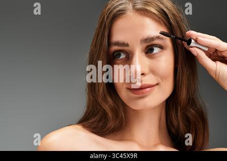 Eine schöne junge Frau trägt Augenbrauengel auf, um ihre Schönheit und ihr Selbstvertrauen zu zeigen. Stockfoto
