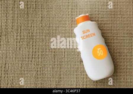 Sonnencreme in Flasche auf Tuch, Draufsicht. Sonnenschutzmittel Stockfoto