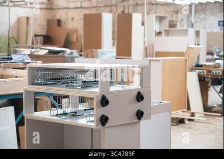 Holzwerkstatt mit verschiedenen Werkzeugen, Möbelteile im Vordergrund Stockfoto