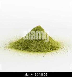 Feines Matcha-Grüntee-Pulver auf weißem Hintergrund, isoliert, lebendige Farbe, gesunde Getränkezutat. Stockfoto
