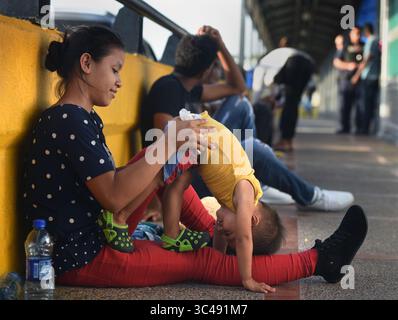 1. Juli 2018 – Matamoros, Mexiko – 2. Juli 2018 – Matamoros, Mexiko – Ingrid Perdomo, 18 Jahre alt und ihr einjähriger Sohn Jose Luis schlafen mit anderen Asylsuchenden auf der Gateway International Bridge und warten darauf, von Mexiko aus in die USA zu überqueren. Sie kam mit ihrem Gefährten Luis Miguel, 32 Jahre alt, aus Honduras, wo sie die schwierige 3-monatige Reise machten. Er sagte, er floh vor Angst und weinte viel vor Angst über seine Vergangenheit. Seine Ex-Frau fing an, mit einem Bandenmitglied auszugehen, und die Gang zündete sein Haus an und tötete seine beiden Kinder darin. Er floh in die Berge, um Sicherheit zu suchen, wo er Ingrid traf und sie ein weiteres Kind hatten. Wie Stockfoto