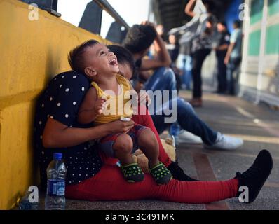 1. Juli 2018 – Matamoros, Mexiko – 2. Juli 2018 – Matamoros, Mexiko – Ingrid Perdomo, 18 Jahre alt und ihr einjähriger Sohn Jose Luis schlafen mit anderen Asylsuchenden auf der Gateway International Bridge und warten darauf, von Mexiko aus in die USA zu überqueren. Sie kam mit ihrem Gefährten Luis Miguel, 32 Jahre alt, aus Honduras, wo sie die schwierige 3-monatige Reise machten. Er sagte, er floh vor Angst und weinte viel vor Angst über seine Vergangenheit. Seine Ex-Frau fing an, mit einem Bandenmitglied auszugehen, und die Gang zündete sein Haus an und tötete seine beiden Kinder darin. Er floh in die Berge, um Sicherheit zu suchen, wo er Ingrid traf und sie ein weiteres Kind hatten. Wie Stockfoto