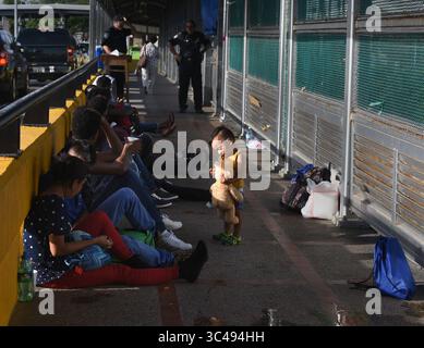1. Juli 2018 – Matamoros, Mexiko – 2. Juli 2018 – Matamoros, Mexiko – Ingrid Perdomo, 18 Jahre alt und ihr einjähriger Sohn Jose Luis schlafen mit anderen Asylsuchenden auf der Gateway International Bridge und warten darauf, von Mexiko aus in die USA zu überqueren. Sie kam mit ihrem Gefährten Luis Miguel, 32 Jahre alt, aus Honduras, wo sie die schwierige 3-monatige Reise machten. Er sagte, er floh vor Angst und weinte viel vor Angst über seine Vergangenheit. Seine Ex-Frau fing an, mit einem Bandenmitglied auszugehen, und die Gang zündete sein Haus an und tötete seine beiden Kinder darin. Er floh in die Berge, um Sicherheit zu suchen, wo er Ingrid traf und sie ein weiteres Kind hatten. Wie Stockfoto