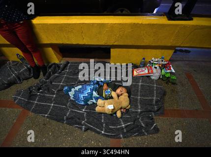 1. Juli 2018 – Matamoros, Mexiko – 2. Juli 2018 – Matamoros, Mexiko – Ingrid Perdomo, 18 Jahre alt und ihr einjähriger Sohn Jose Luis schlafen mit anderen Asylsuchenden auf der Gateway International Bridge und warten darauf, von Mexiko aus in die USA zu überqueren. Sie kam mit ihrem Gefährten Luis Miguel, 32 Jahre alt, aus Honduras, wo sie die schwierige 3-monatige Reise machten. Er sagte, er floh vor Angst und weinte viel vor Angst über seine Vergangenheit. Seine Ex-Frau fing an, mit einem Bandenmitglied auszugehen, und die Gang zündete sein Haus an und tötete seine beiden Kinder darin. Er floh in die Berge, um Sicherheit zu suchen, wo er Ingrid traf und sie ein weiteres Kind hatten. Wie Stockfoto