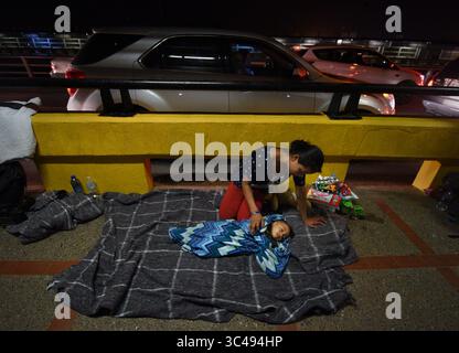 1. Juli 2018 – Matamoros, Mexiko – 2. Juli 2018 – Matamoros, Mexiko – Ingrid Perdomo, 18 Jahre alt und ihr einjähriger Sohn Jose Luis schlafen mit anderen Asylsuchenden auf der Gateway International Bridge und warten darauf, von Mexiko aus in die USA zu überqueren. Sie kam mit ihrem Gefährten Luis Miguel, 32 Jahre alt, aus Honduras, wo sie die schwierige 3-monatige Reise machten. Er sagte, er floh vor Angst und weinte viel vor Angst über seine Vergangenheit. Seine Ex-Frau fing an, mit einem Bandenmitglied auszugehen, und die Gang zündete sein Haus an und tötete seine beiden Kinder darin. Er floh in die Berge, um Sicherheit zu suchen, wo er Ingrid traf und sie ein weiteres Kind hatten. Wie Stockfoto