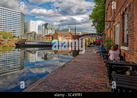 Leute, die vor einem Pub am Kanal sitzen, genießen einen Drink in der Sonne im Gas Street Basin, Birmingham City Centre. Stockfoto